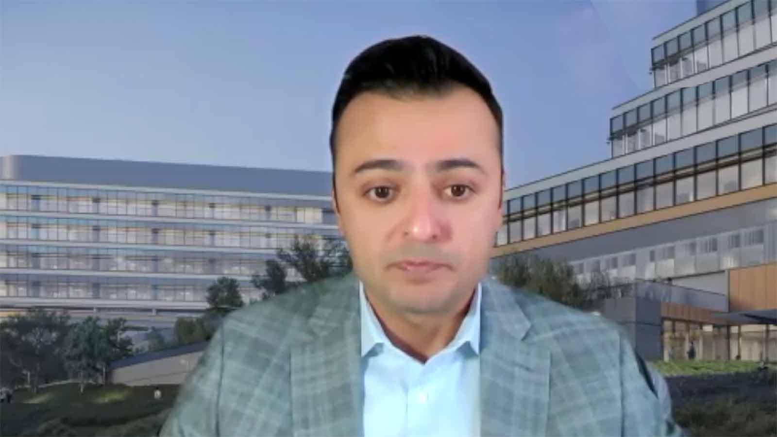 A man in a suit and tie standing next to a building.